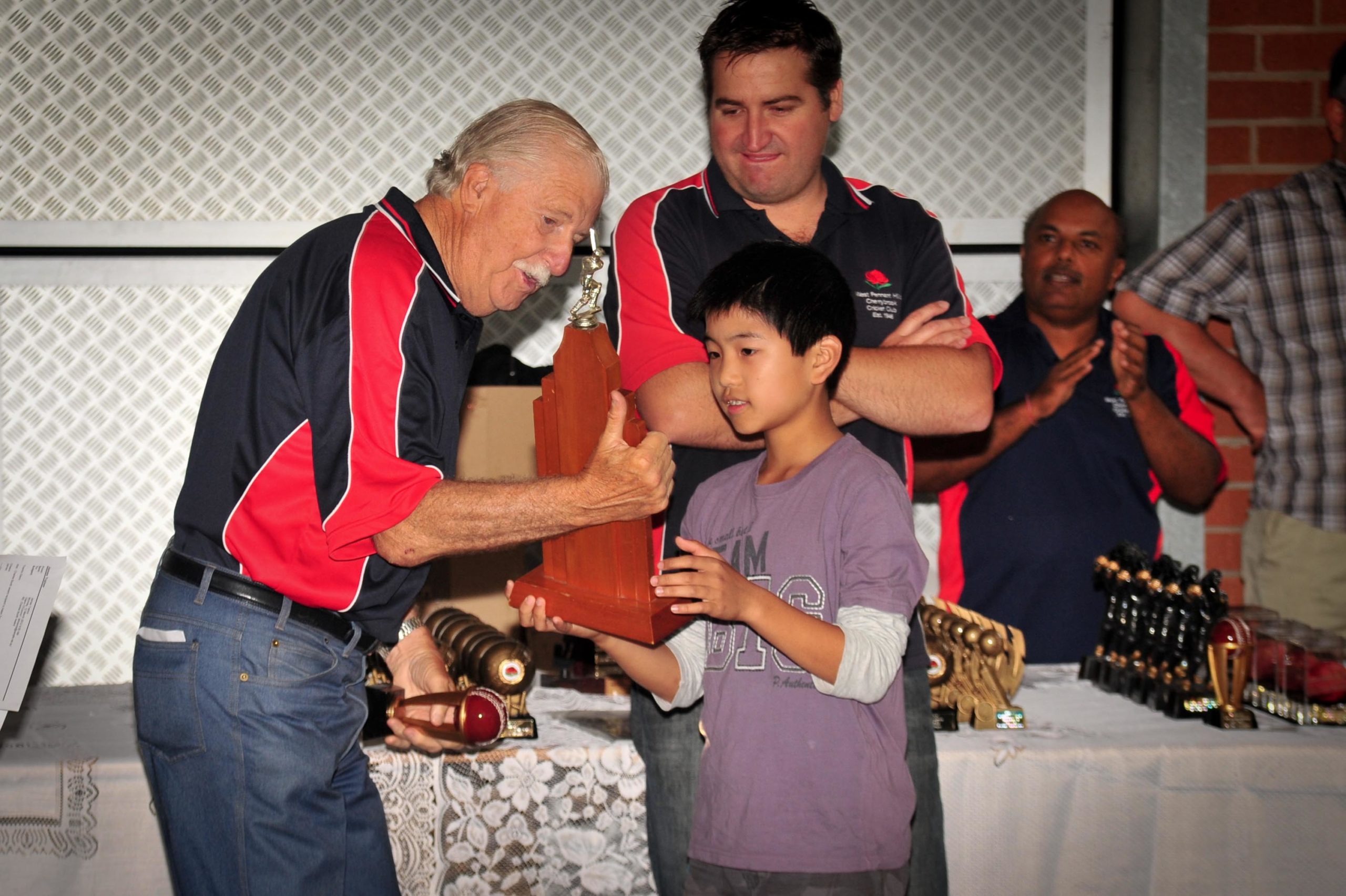 Adam Tan receiving the Charles Booth Memorial Trophy (2011/12) from Barry McDonald (left) and Glenn O'Connor with Deepak Narsai in the background.